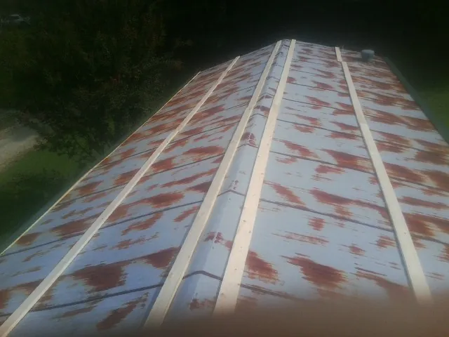 Rusted metal roof panels with new wood purlins before replacement — Storm Damage Roof Repair in Verona by Roofing Brothers